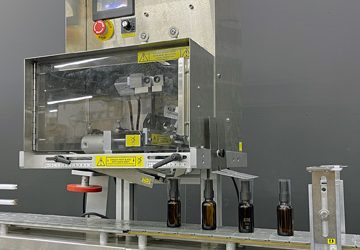 Neck Banding Machine Applies Shrinkbands to Tiny Bottles Automatically