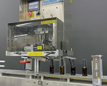 Neck Banding Machine Applies Shrinkbands to Tiny Bottles Automatically