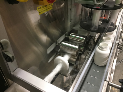 Pharmafill CS10 cotton insertion machine closeup of pinch roller assembly