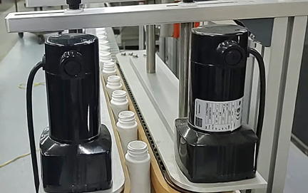 Deitz-BCV1-Testing-Line-lores Pharmafill bottomless conveyor transferring white plastic bottles at Deitz