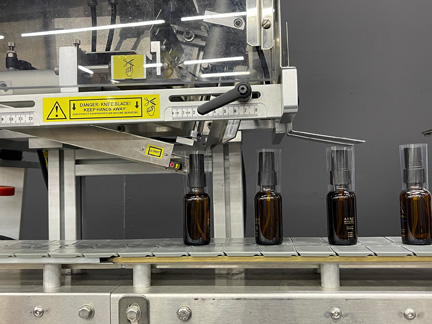 Pharmafill NB1 tamper-evident neck banding machine applies shrinkbands onto glass dropper bottles